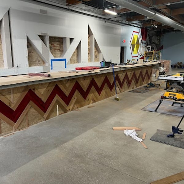 Oddfellows' bar under construction, featuring a chevron pattern of red and natural wood.