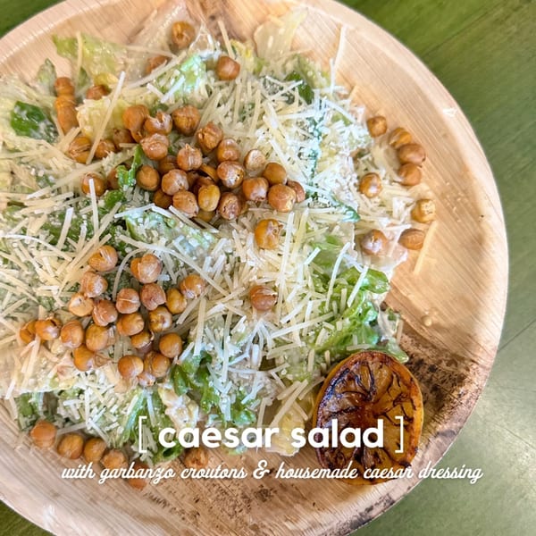 Oddfellows' Caesar salad with garbanzo croutons, shredded cheese, and a grilled lemon wedge.